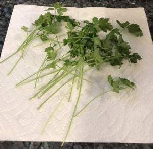 How to Dry Parsley Step 3: Lay the stalks on a paper towel and blot dry them with another paper towel.