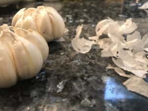 Carefully peel the papery skins off of the garlic bulb.